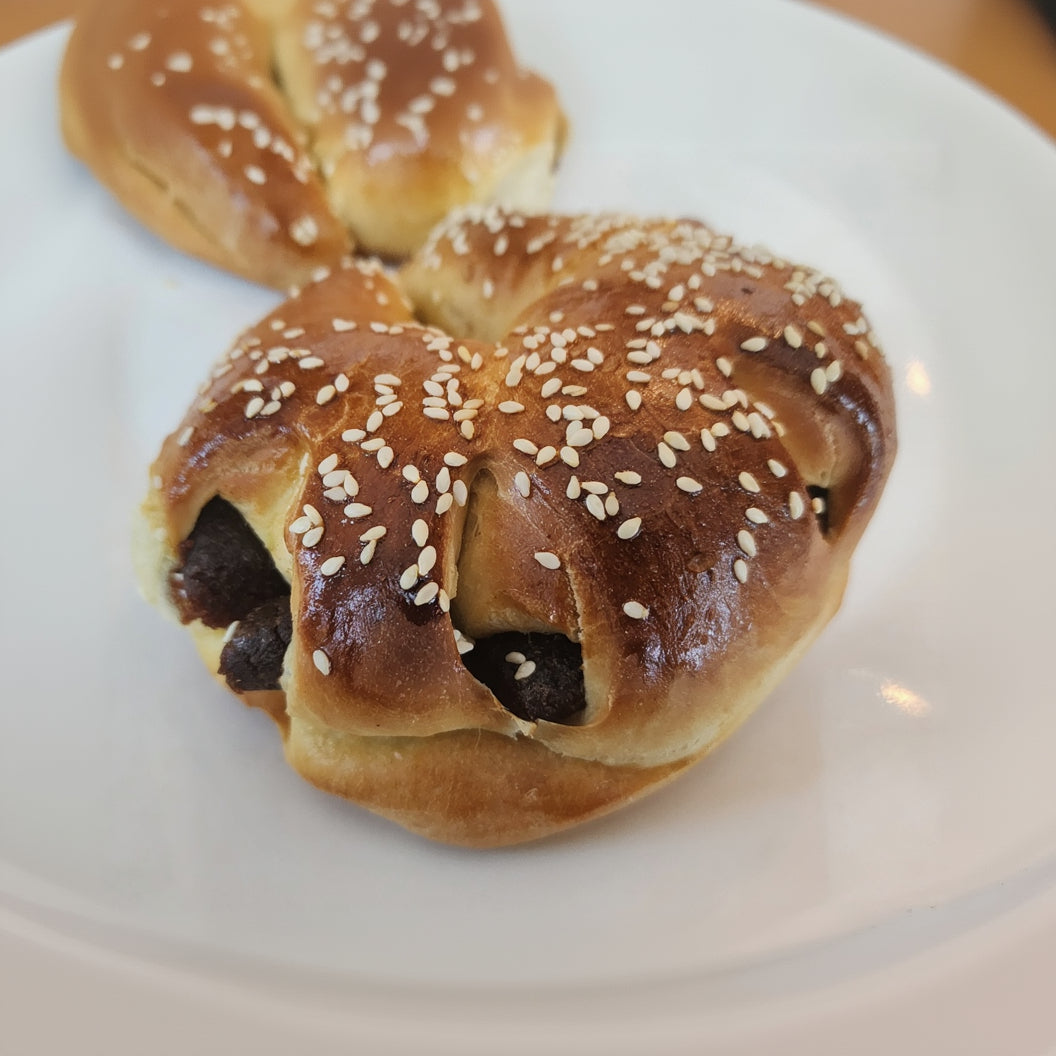 Baked date bread with sesame seeds on a white plate