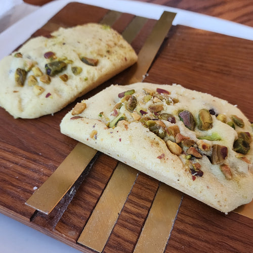 Two ghouribeh pistachio with nuts on a wooden cutting board