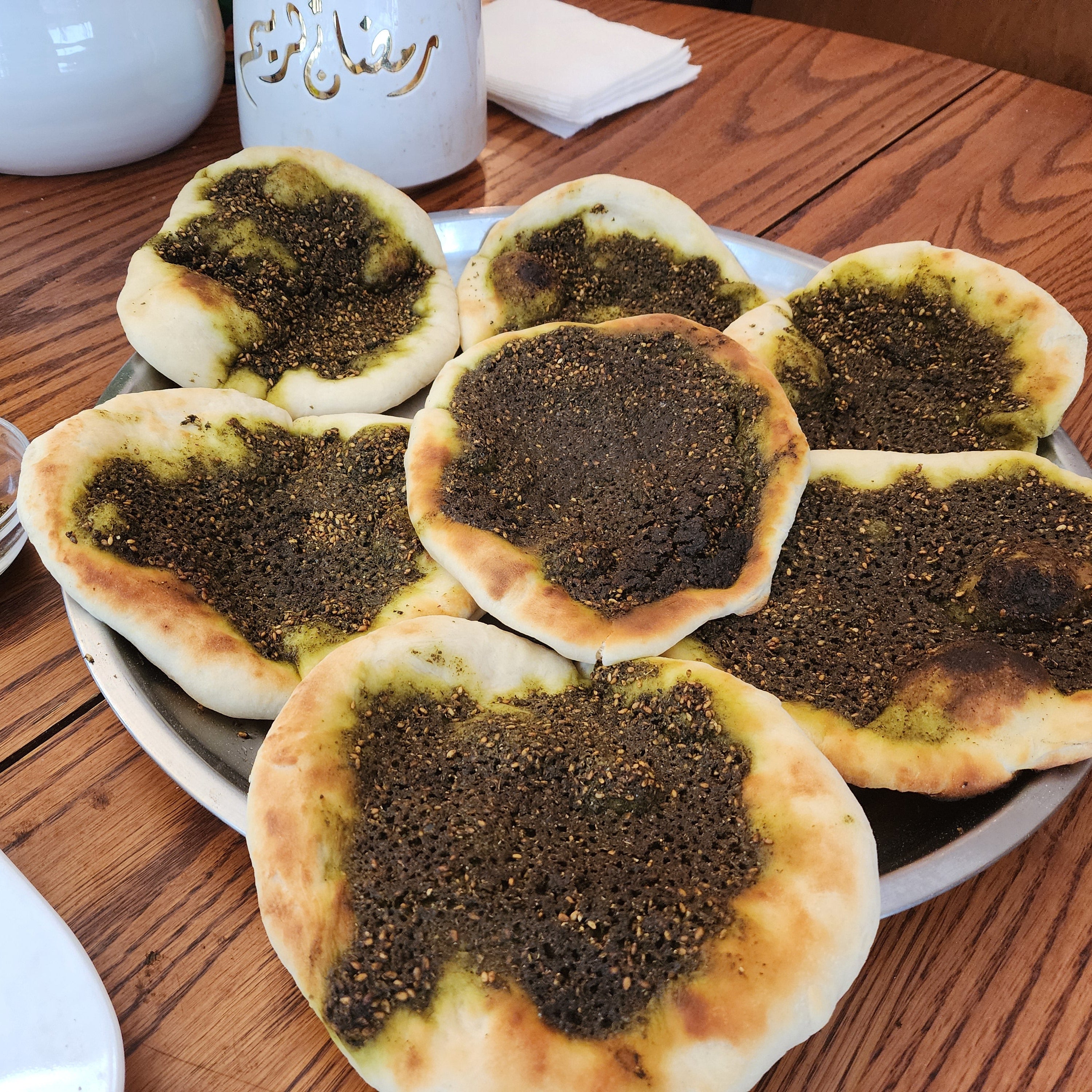 Zaatar Pies on a wooden table with small bowls of spices.